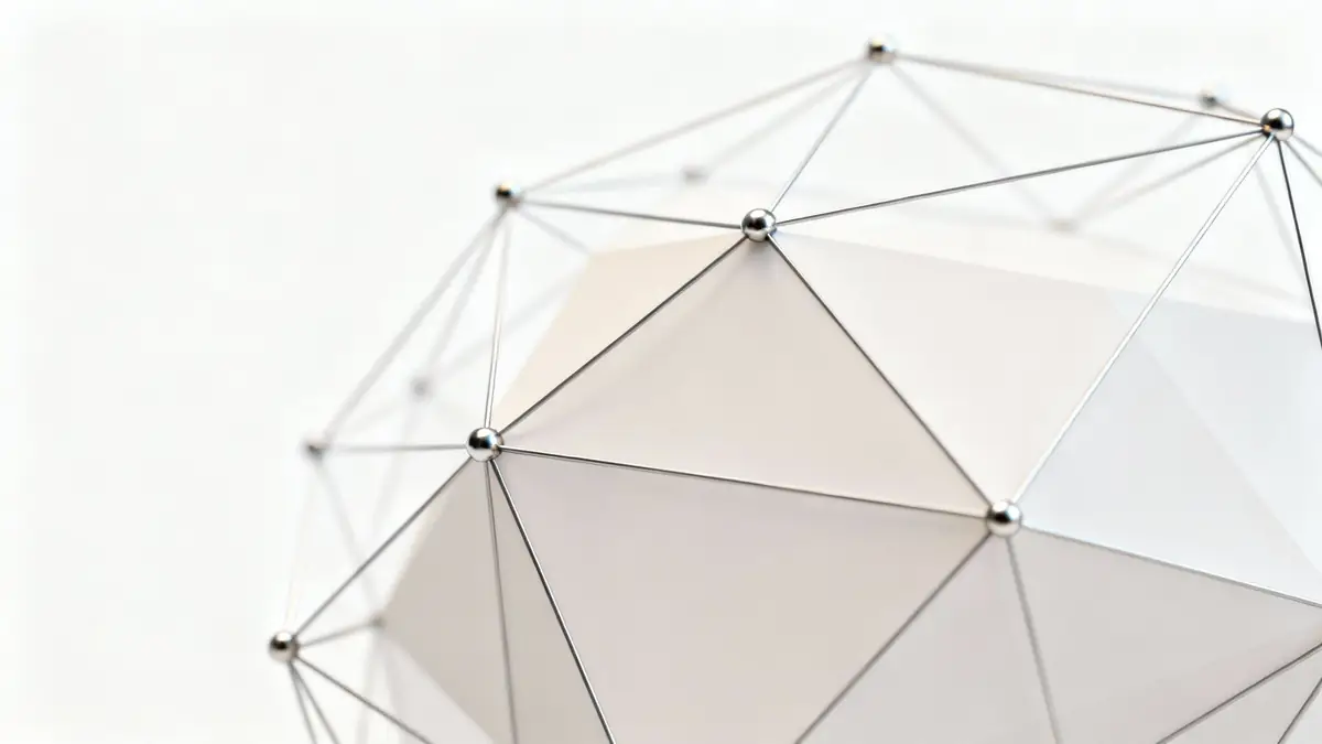 Close-up of a metallic geodesic sphere with a white, facetted interior against a light background.